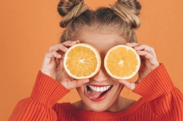 Jeune femme avec deux moitiés d'orange sur les yeux - huiles essentielles